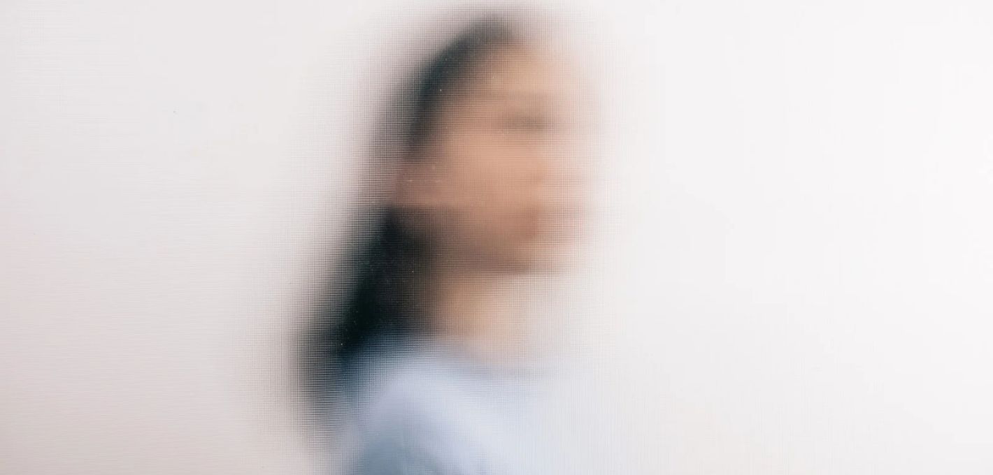 Propriozeption Verschwommene Frau hinter Milchglas als Bild für Propriozeption und ein unklares Gefühl für den eigenen Körper